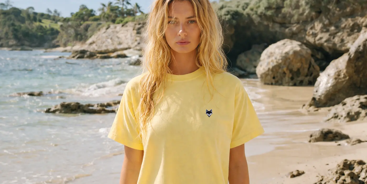 Femme portant un t-shirt vanlife jaune en bord de mer – ambiance été et liberté