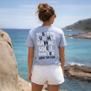 Femme de dos portant un t-shirt en coton bio de couleur lila devant la mer méditerrannée dans le sud de la france lors d'une randonnée