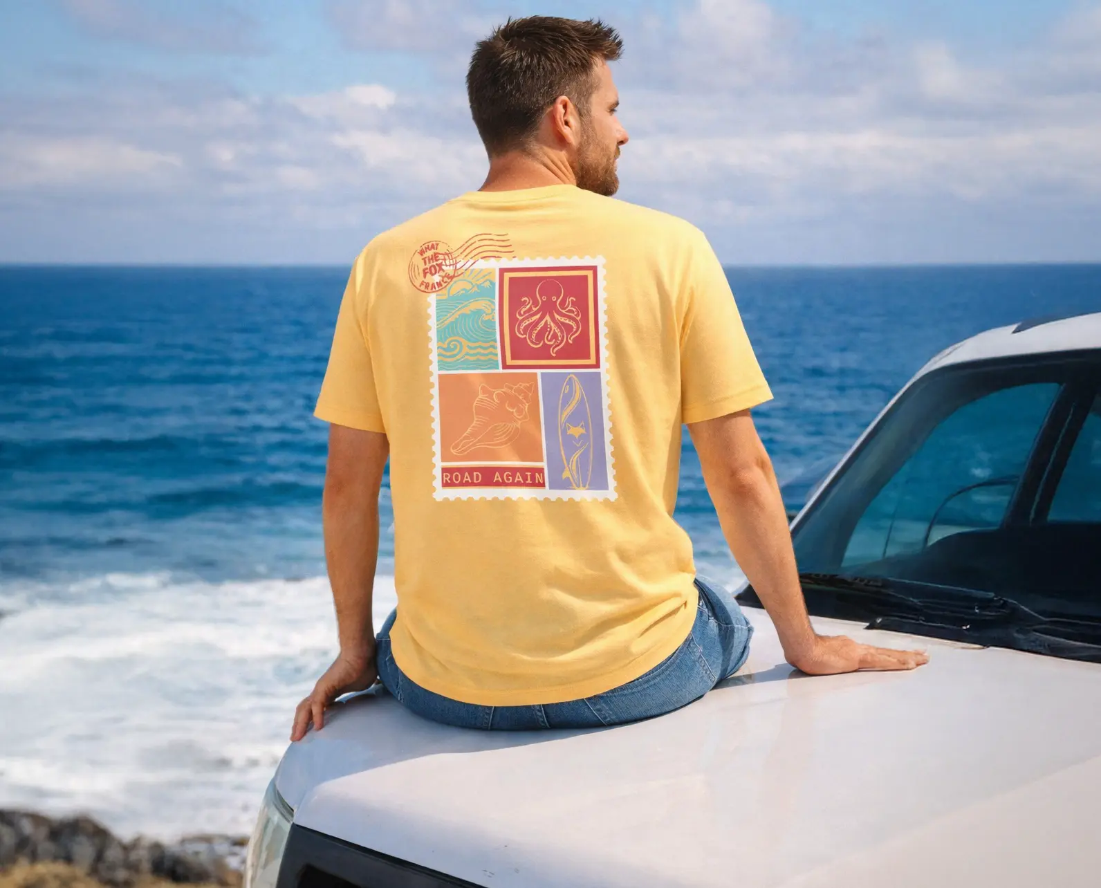 homme portant le tee shirt solaris de dos assis sur le capot de son van en bord de mer sur la cote d'azur